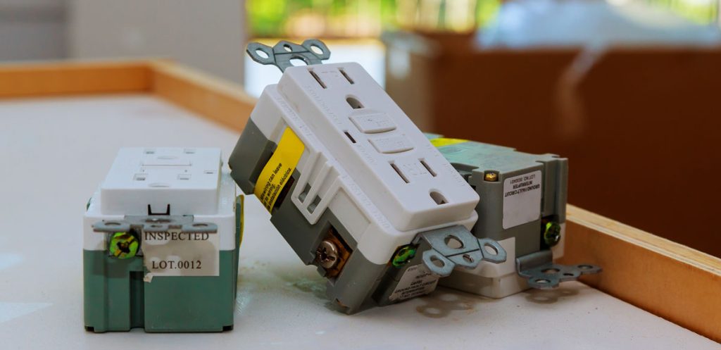 A new white duplex outlet half-mounted in its wall box, the sort of outlet and switch replacement covered by ENS electric's residential electrical service.